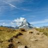 Iconic Matterhorn mountain in Switzerland with a rocky trail under a clear blue sky.