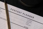 Vertical shot of a podcast planner and pen on a dark table, ideal for business and planning concepts.