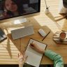 A student taking notes during a video call for online learning at home.