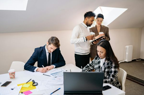 A diverse group of colleagues collaborating on a project in a modern office setting.
