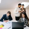 A diverse group of colleagues collaborating on a project in a modern office setting.