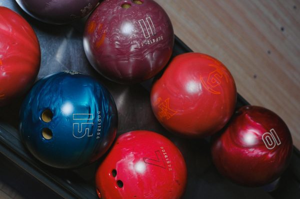 Close-up of colorful bowling balls in a rack, capturing leisure and fun.