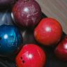 Close-up of colorful bowling balls in a rack, capturing leisure and fun.