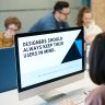 Group of designers collaborating in modern office space with computer.