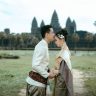 A couple in traditional Cambodian attire embracing at Angkor Wat, a symbol of timeless love.