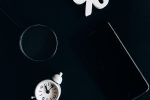 Stylish composition of clock, symbols, and text representing financial change on a dark background.