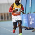 African male athlete participates in an Abu Dhabi marathon, showcasing determination and fitness outdoors.