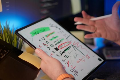 A person managing tasks on a tablet with a digital pen in a modern office setting.