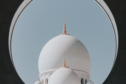 Elegant view of the Sheikh Zayed Grand Mosque dome framed by an arch in Abu Dhabi, UAE.