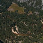 Stunning aerial shot of Yosemite Valley's lush forest and winding river, showcasing nature's beauty.