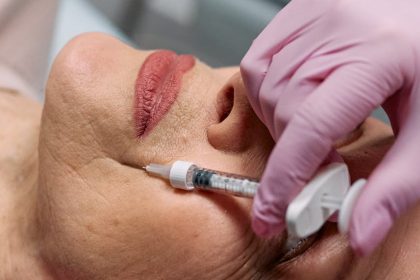 Close-up of a beautician administering a Botox injection to a woman at a clinic.