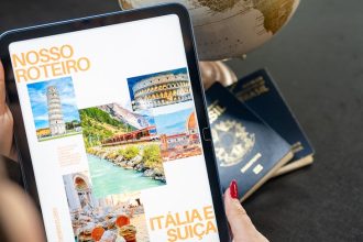 Traveler planning a trip to Italy and Switzerland using a globe, tablet, and passports.