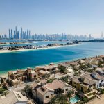 A breathtaking aerial view of Dubai's skyscrapers and luxury villas on a sunny day.