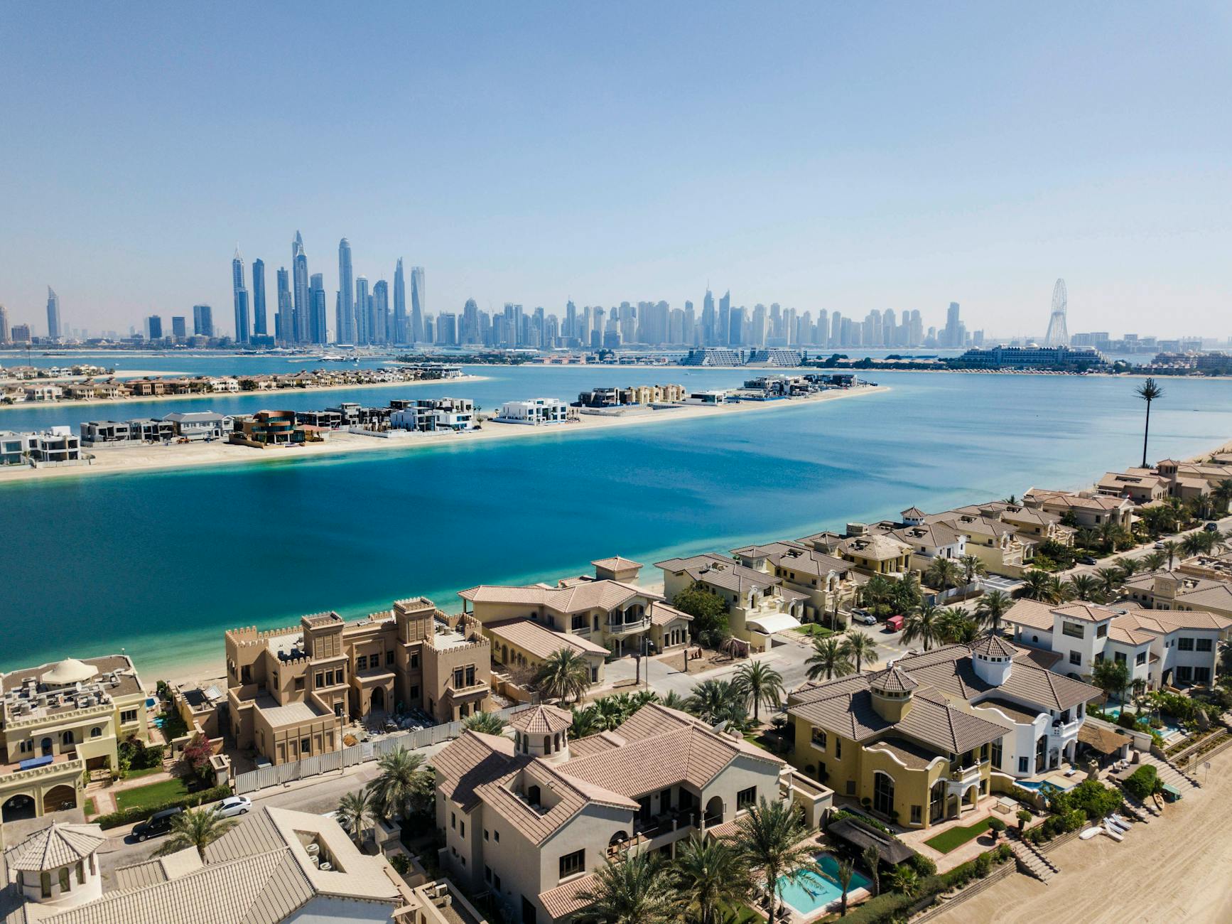 A breathtaking aerial view of Dubai's skyscrapers and luxury villas on a sunny day.