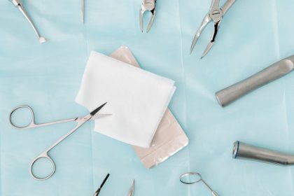 Top view of assorted dental surgical instruments on a blue background, sterile and ready for use.