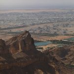 Breathtaking view from the mountains showcasing an arid landscape and a city below.