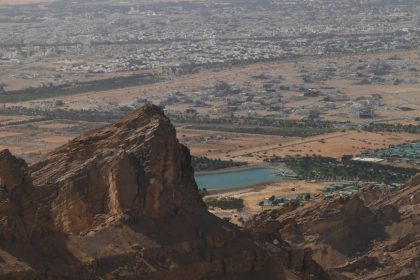 Breathtaking view from the mountains showcasing an arid landscape and a city below.