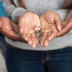 Close-up of hands holding a key, representing new homeownership and property investment.