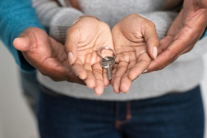 Close-up of hands holding a key, representing new homeownership and property investment.