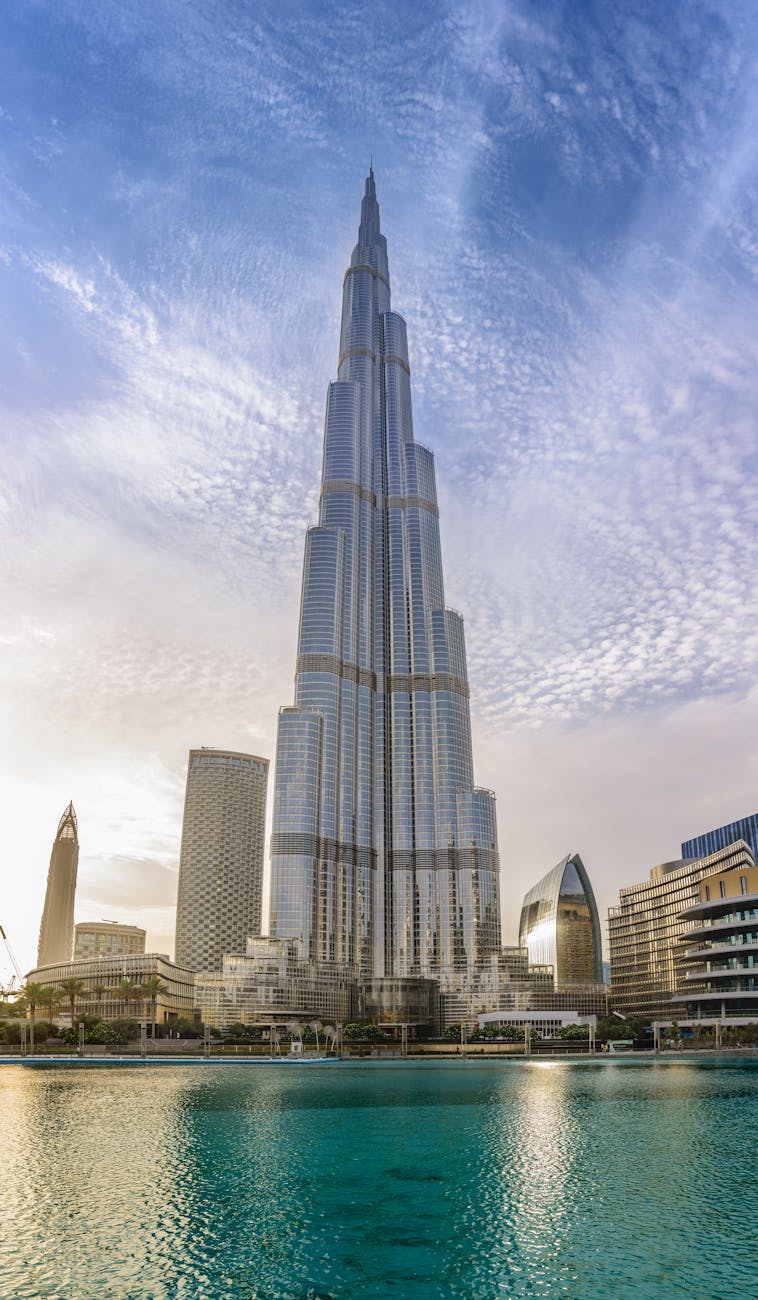 Majestic Burj Khalifa against a bright blue sky reflecting in water, Dubai.